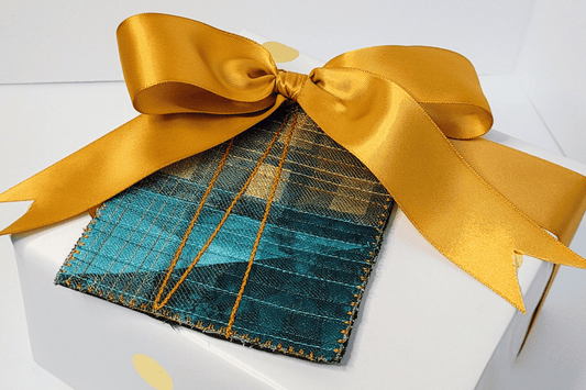 Photo of wrapped gift feature a mini art quilt gift tag